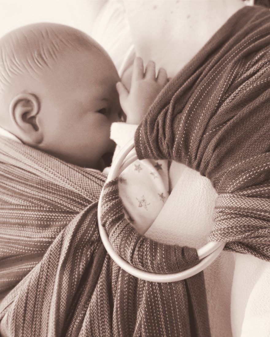Bébé blotti contre sa maman dans une écharpe sling à anneaux
