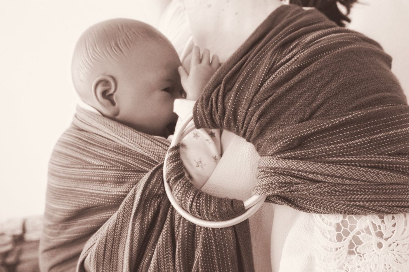 Bébé blotti contre sa maman dans une écharpe sling à anneaux
